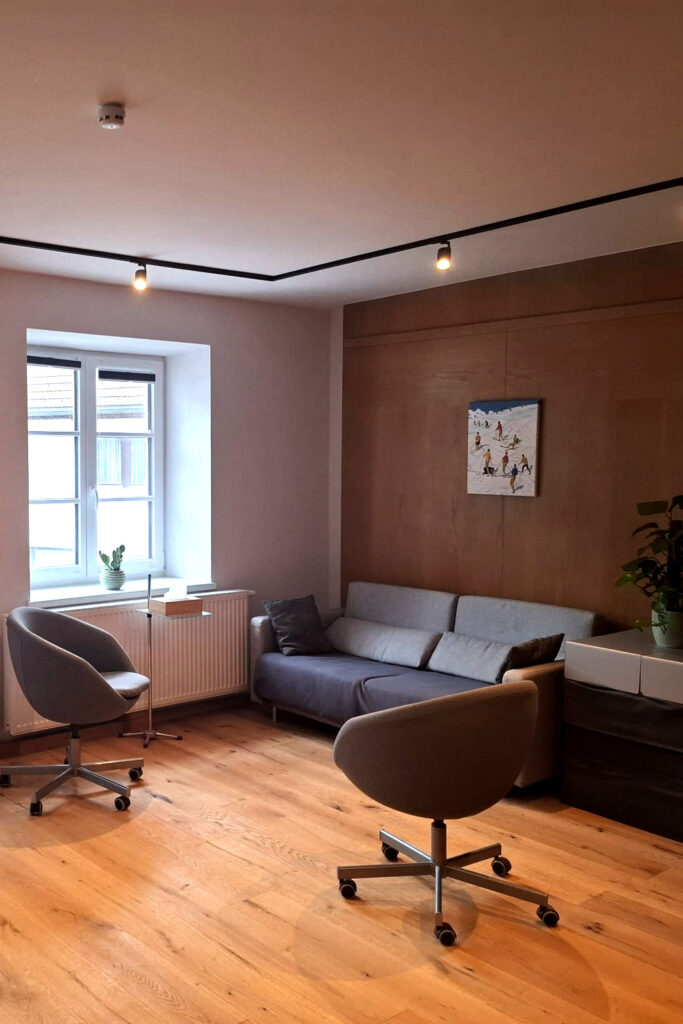 Sprechzimmer mit Couch und zwei Sesseln am Fenster